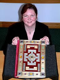 Dr. Michelle Brown holding the Lindisfarne Gospels. She is an expert on these Gospels.